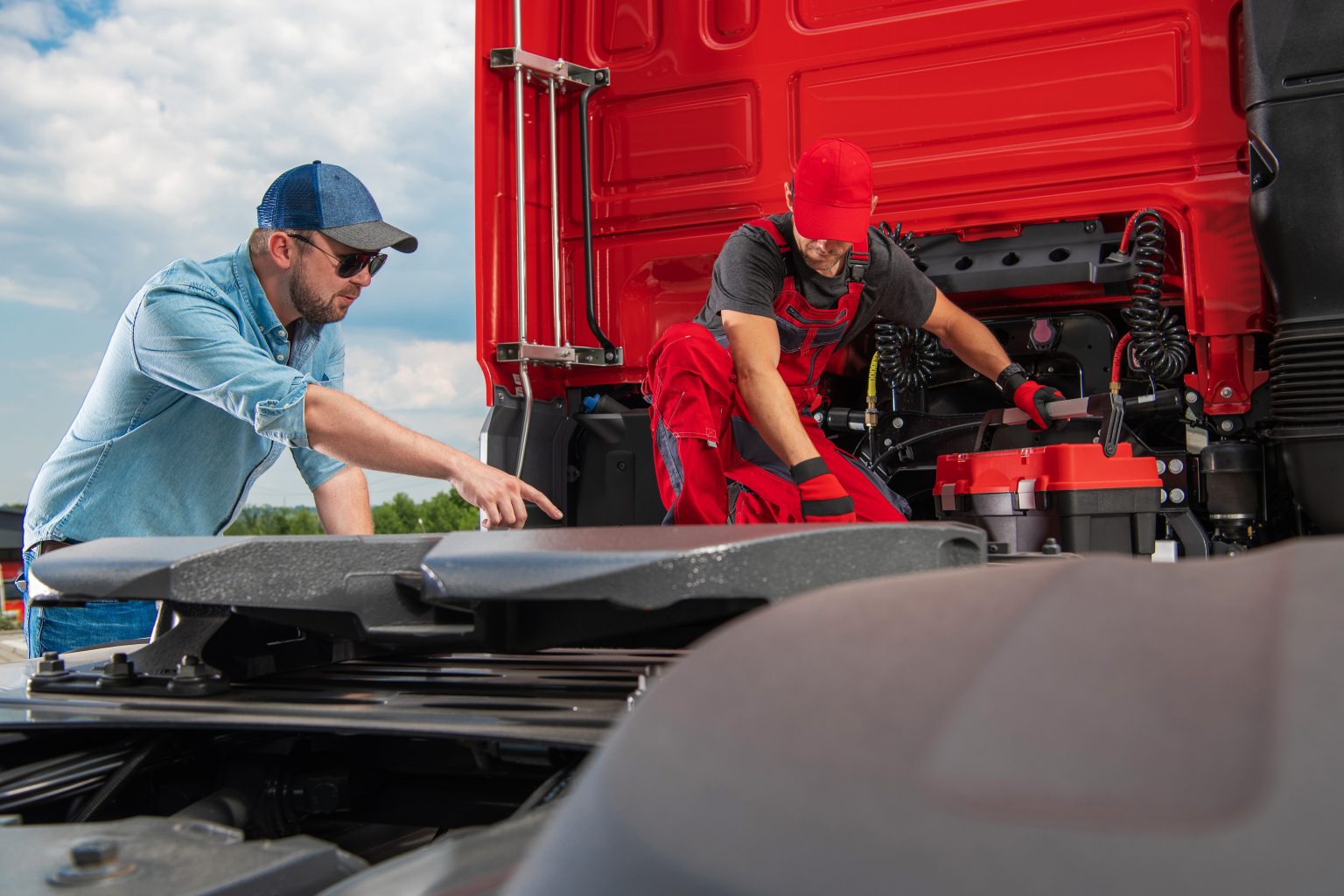 owner operator inspecting heavy duty truck with mechanic