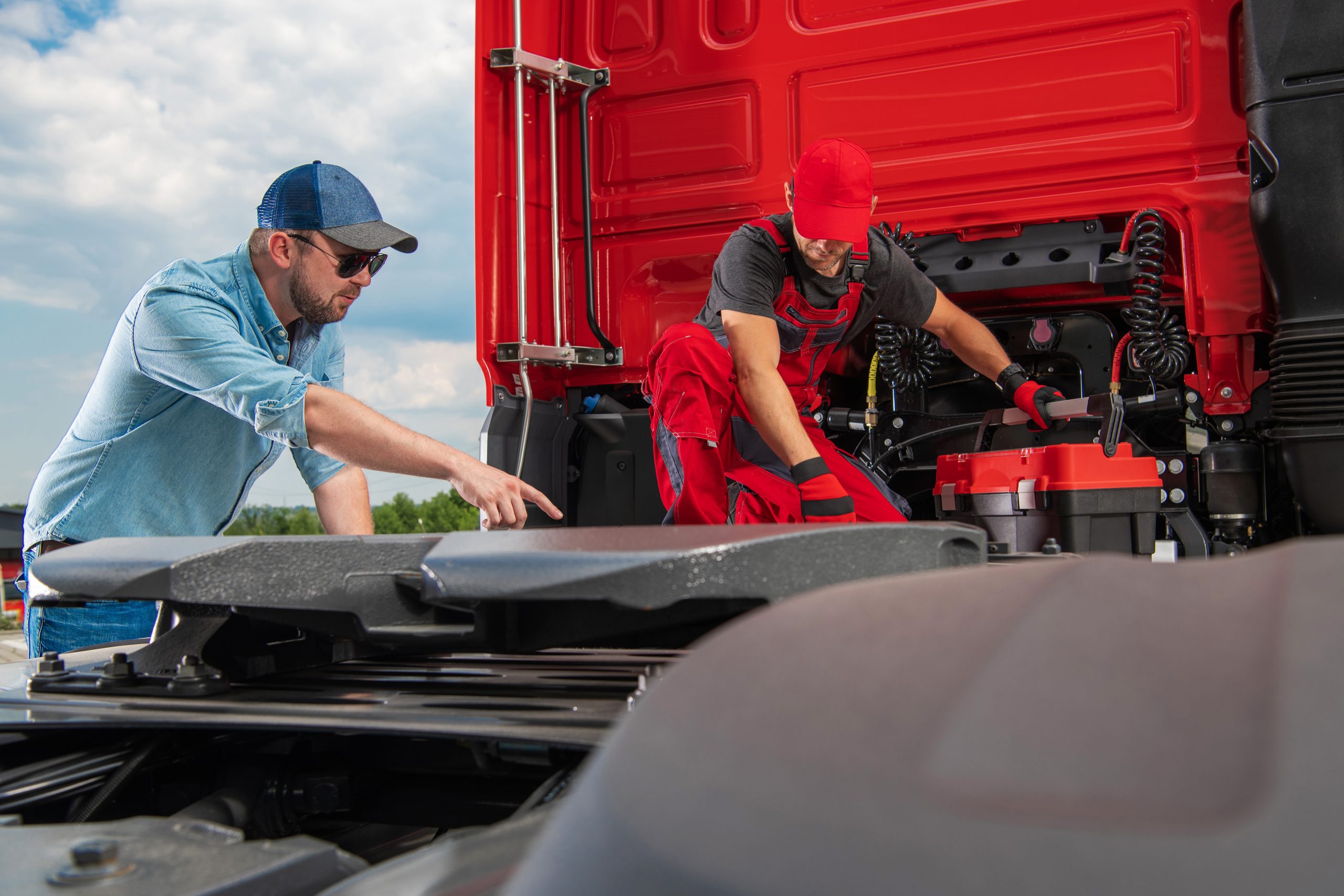 owner operator inspecting heavy duty truck with mechanic